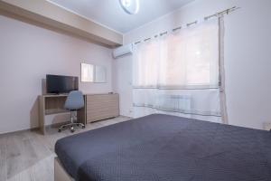 um quarto com uma cama, uma secretária e uma janela em Damilhouse 1 em Messina