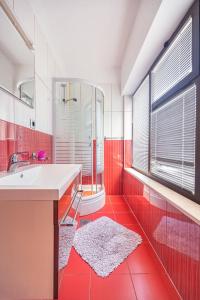 a red bathroom with a sink and a shower at Apartmani Baki in Podstrana