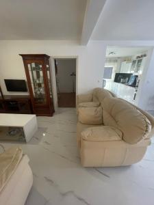 ein weißes Wohnzimmer mit einem Sofa und einem Tisch in der Unterkunft Holiday Home 1 in Bibinje