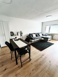salon ze stołem i kanapą w obiekcie BeBu - Apartment w mieście Friedrichshafen