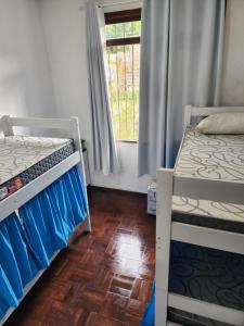 1 dormitorio con 2 literas y ventana en Hostel Lumaria 1, en Blumenau