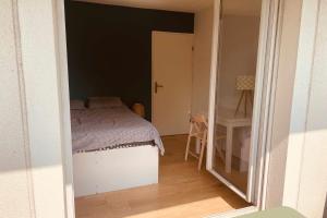 a small bedroom with a bed and a desk at Spacious 69 m nest with balcony in Aubervilliers