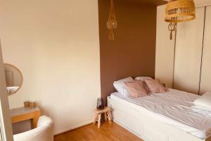 a bedroom with a bed with pink pillows on it at Spacious 69 m nest with balcony in Aubervilliers