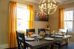 a dining room table with chairs and a chandelier at Hidden Gem Secluded Home Steps from Bike Path in Schenectady