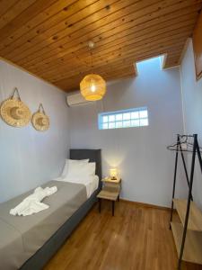 Searenity Home في Ropanianá: غرفة نوم بسرير وسقف خشبي