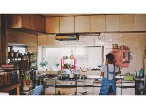 Asa的住宿－HOMESTAY Kucha - Vacation STAY 17860v，站在厨房准备食物的妇女