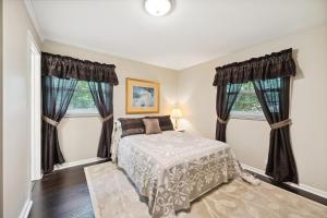um quarto com uma cama e duas janelas em Greensboro Golf Getaway - 9 Mi to Downtown! em Greensboro