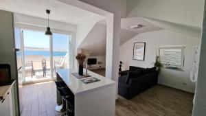 a living room with a couch and a living room with the ocean at Belvedere Premium in Novalja