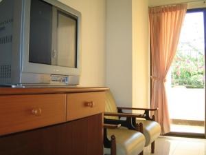 a room with a tv on a dresser and a window at Wipanan Mansion in Chiang Mai