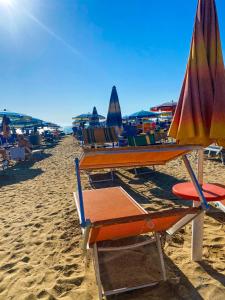 um grupo de cadeiras de praia e um guarda-sol na praia em TE BUJTINA HOTEL em Golem