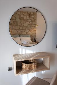 um espelho numa parede com uma cama num quarto em Michelangelo suites and apartments em Valanidorachi