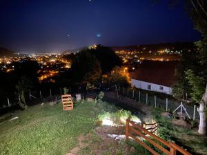 a view of a field at night with a city at Chalets du BF in Sighişoara