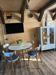 a dining room with a table and chairs and a tv at Chalets du BF in Sighişoara