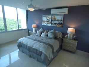 una camera da letto con un letto con pareti e finestre blu di 7i Luxury Resort Lifestyle Ocean Views a ArraijÃ¡n Altre 20 foto