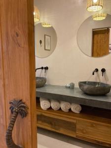 a bathroom with two sinks and two mirrors at Ohana Villas in Santa Teresa Beach
