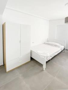 Cette chambre blanche comprend un lit blanc. dans l'établissement Elegant 4 beds near train station upto 10 Pax, Castellón de la Plana