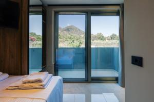 Zimmer mit einem Bett und einem großen Glasfenster in der Unterkunft Isla Villas & Suites in Balíon