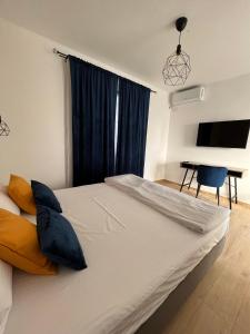 1 dormitorio con 1 cama blanca grande con almohadas azules en Maison 25, en 2 Mai