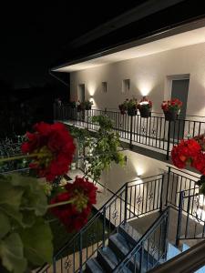 un balcón con flores rojas en un edificio en Maison 25, en 2 Mai