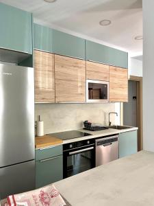 una cocina con armarios azules y electrodomésticos de acero inoxidable en Apartamento Valbuena, en Potes