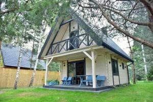 una piccola casa bianca con portico e tavolo di Biały Domek a Żary