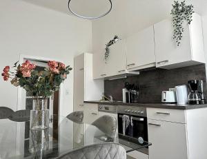 a kitchen with a glass table with a vase of flowers at Stylish Apartment, next to Schloss Belvedere in Vienna