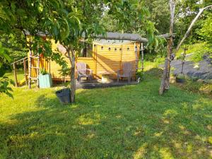 una casa amarilla con dos sillas en un patio en Maison Dougnac La Chamane, en Fleurance