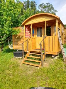 a wooden cabin with stairs in the grass at Maison Dougnac La Chamane in Fleurance