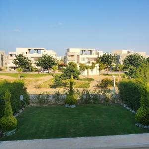 a small green yard with buildings in the background at Amwaj north Coast 