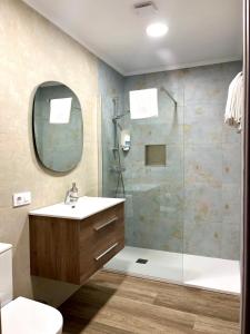 a bathroom with a sink and a shower with a mirror at Apartamento Valbuena in Potes
