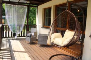 a porch with a swinging chair on a patio at Resort Lesní Lázně in Zvánovice