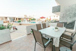 un tavolo e sedie su un patio con piscina di Villa Popi Studios (Froso) a Kefalos