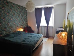 - une chambre avec un lit et une table avec une lampe dans l'établissement L'Eau Vive, à Dinan