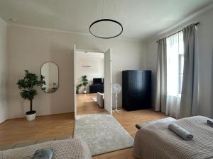 Sala de estar con 2 camas y espejo en Stylish Apartment, next to Schloss Belvedere, en Viena
