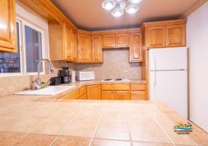 uma cozinha com armários de madeira e um frigorífico branco em Magnificent San Felipe Beach side condo - Jerry`s condo #1 em San Felipe