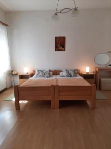 a bedroom with a large bed with two lamps on it at Apartment Gorska vila in Ogulin