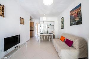 uma sala de estar com um sofá e uma televisão de ecrã plano em [Fronte Mare]-Sweet Home-[Free Parking] em Marina di Pisa