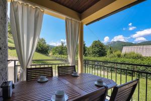 a table on a balcony with a view of the mountains at Holiday House Provance in Brod na Kupi