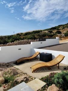 two wooden benches sitting on a patio with a table at Belvedere Premium in Novalja