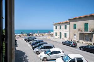 rząd samochodów zaparkowanych na parkingu obok plaży w obiekcie [Fronte Mare]-Sweet Home-[Free Parking] w mieście Marina di Pisa