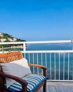 a chair with a pillow sitting on a balcony overlooking the ocean at Sea La Vie - Terrazza sul mare in Agropoli