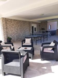 eine Terrasse mit Tischen und Stühlen sowie einer Tischtennisplatte in der Unterkunft Apartment Gorska vila in Ogulin