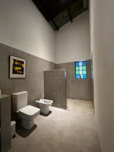 een badkamer met een toilet, een wastafel en een raam bij Casa frente al Río Paraná in Paso de la Patria
