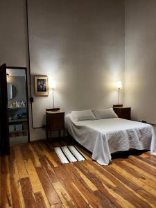 een slaapkamer met een wit bed en een houten vloer bij Casa frente al Río Paraná in Paso de la Patria