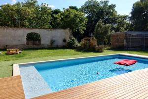 a swimming pool in a yard with a wooden deck at Château de Fontanas, le Puits in Grisolles