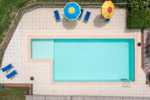 una vista aérea de una piscina con sombrillas y sillas en Agriturismo Cantine Bevione - Rooms with air conditioning en Belvedere Langhe