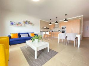 a living room with a blue couch and a table at Deluxe 2 Bedroom Flat - BeachFront - Praia Del Rey in Amoreira