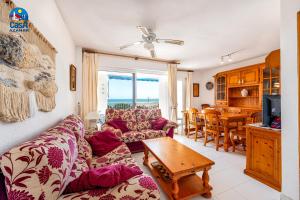 ein Wohnzimmer mit einem Sofa und einem Tisch in der Unterkunft Apartamentos La Noria Casa Azahar in Alcossebre