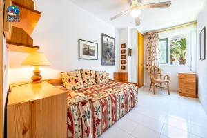 a bedroom with a bed and a desk and a window at Apartamentos La Noria Casa Azahar in Alcossebre