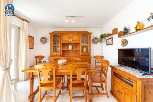 a dining room with a wooden table and chairs at Apartamentos La Noria Casa Azahar in Alcossebre